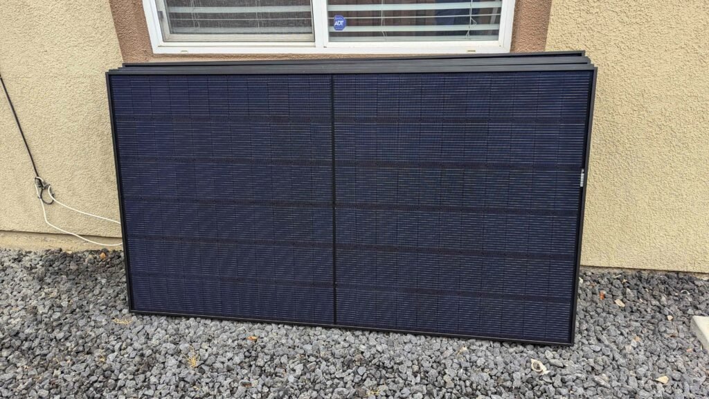 CalPacific Power solar panels stacked outside a Bay Area home, ready for installation. Panels rest against the exterior wall.