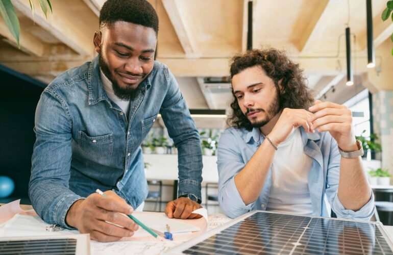 Two energy consultants from CalPacific Power in California reviewing solar panel plans during a solar consultation, emphasizing clean energy solutions.