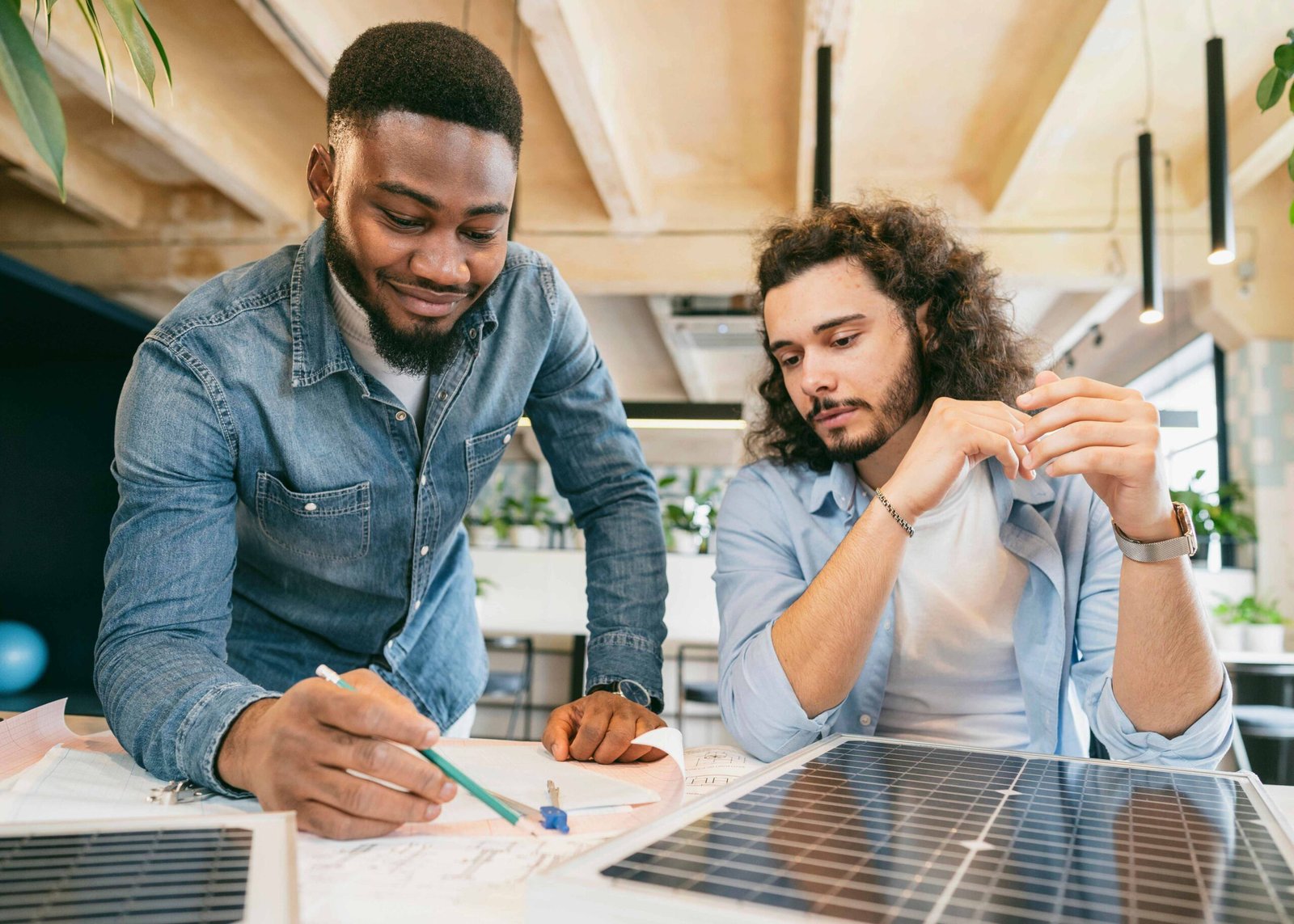 Two energy consultants from CalPacific Power in California reviewing solar panel plans during a solar consultation, emphasizing clean energy solutions.
