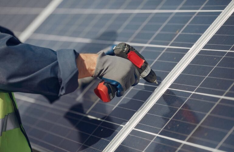 Technician installing solar panel with power drill on rooftop in California, showing hands-on solar energy system setup by CalPacific Power in 2025.