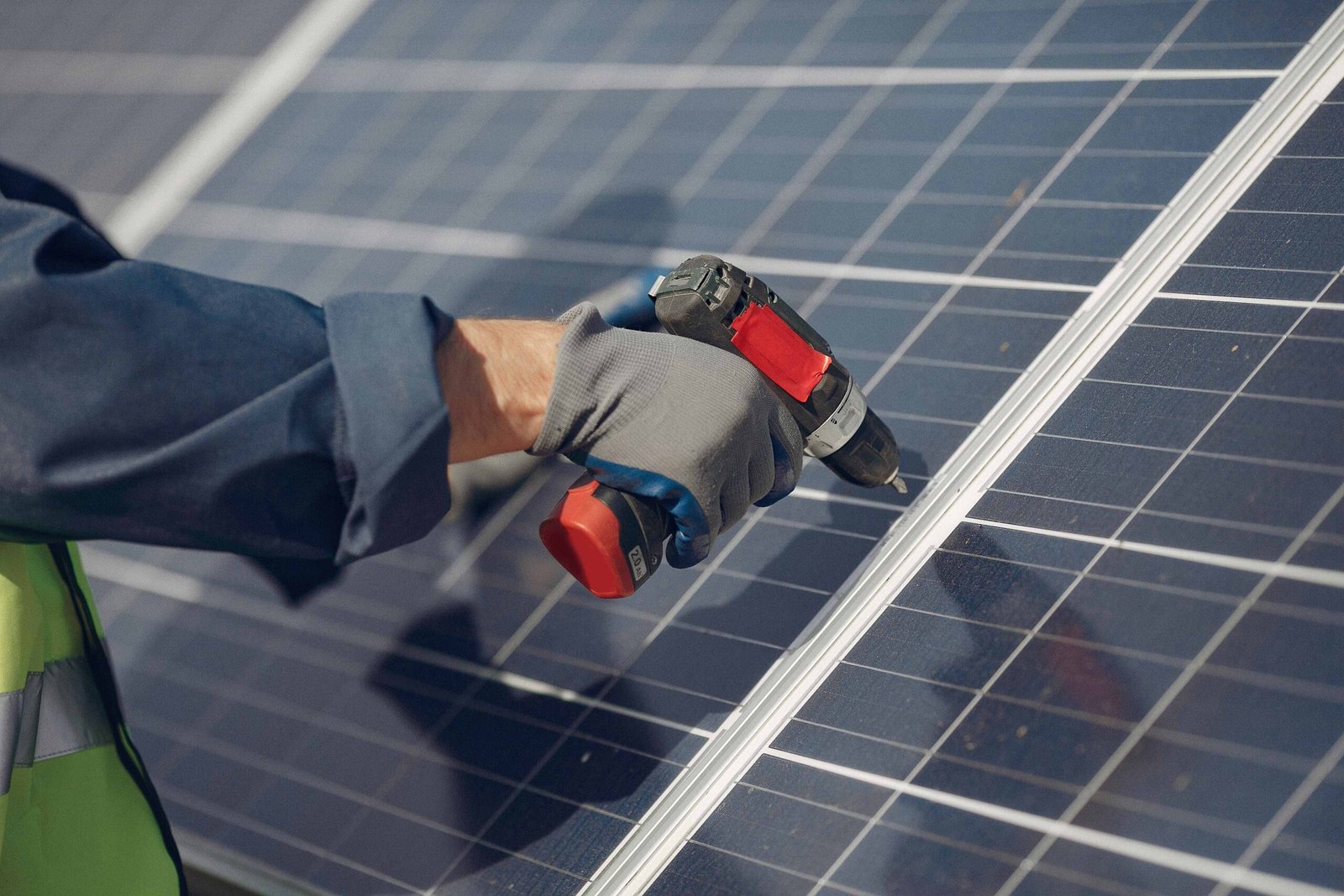 Technician installing solar panel with power drill on rooftop in California, showing hands-on solar energy system setup by CalPacific Power in 2025.